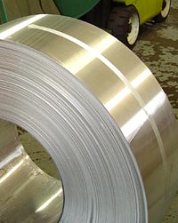A coil of alloy waits for a forklift.